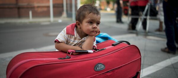 Мальчик ждет родителей возле берлинского офиса для беженцев - Sputnik Беларусь