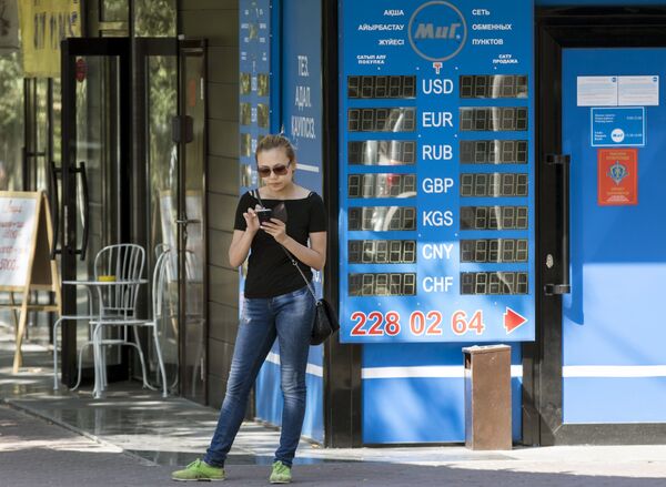 Женщина с ​​мобильным телефоном рядом с обменом валют в Алматы, Казахстан - Sputnik Беларусь