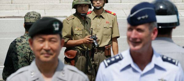 Северокорейские военные (на заднем плане) наблюдают за южнокорейскими военными Северокорейские военные (на заднем плане) наблюдают за южнокорейскими военными - Sputnik Беларусь