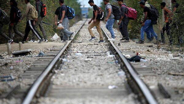 Беженцы пересекают железнодорожную ветку. Архивное фото - Sputnik Беларусь