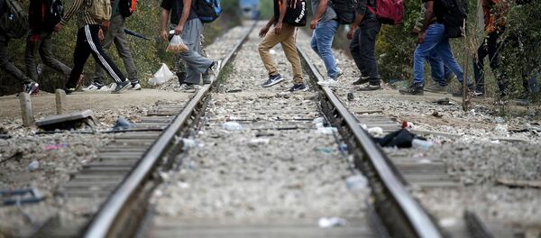 Беженцы пересекают железнодорожную ветку. Архивное фото - Sputnik Беларусь