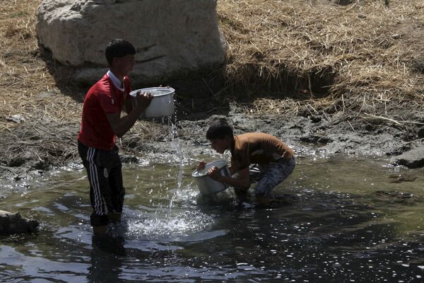 Дети набирают воду в водоеме в Ираке - Sputnik Беларусь
