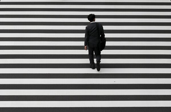 Бизнесмен пересекает дорогу в деловом районе Токио - Sputnik Беларусь