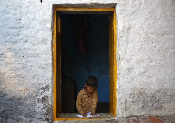 Мальчик читает в окне своего дома - Sputnik Беларусь