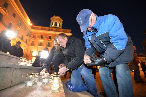 Участник несанкционированного пикета в память о жертвах сталинских репрессий ставят свечи на ступени здания КГБ в Минске - Sputnik Беларусь