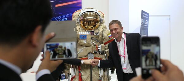 Посетитель фотографируется со скафандром на стенде Роскосмоса - Sputnik Беларусь