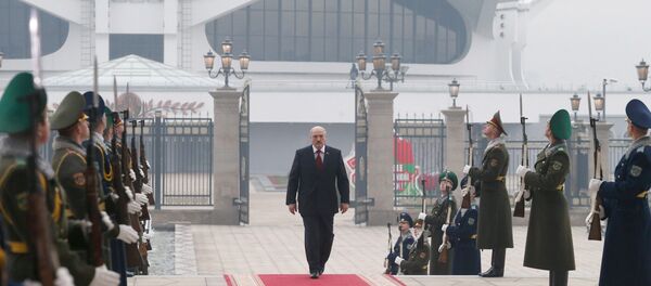 Александр Лукашенко по ковровой дорожке, вдоль которой выстроены военнослужащие роты почетного караула - Sputnik Беларусь