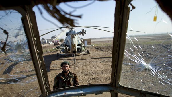 Боец афганской армии смотрит на разбитый российский вертолет. Архивное фото - Sputnik Беларусь