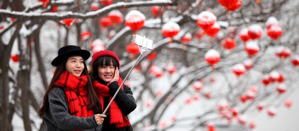 Туристки делают селфи после снегопада в Сиане - Sputnik Беларусь