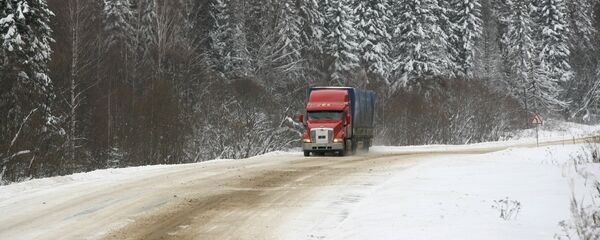 Трейлер едет по участку занесенной снегом дороги - Sputnik Беларусь