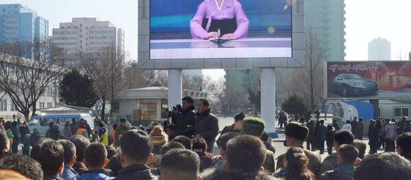 Жители Пхеньяна смотря на экране объявление о запуске ракеты - Sputnik Беларусь