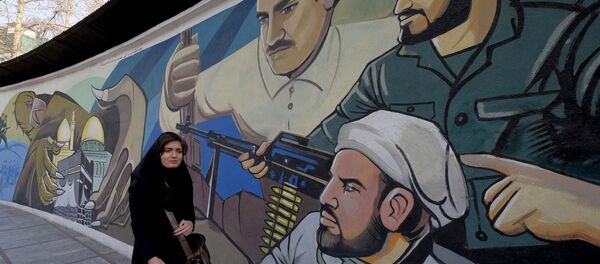 Иранская женщина идет мимо революционного мурала в Тегеране Иранская женщина идет мимо революционного мурала в Тегеране - Sputnik Беларусь