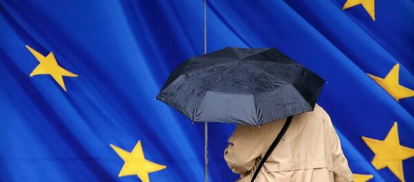 Женщина под зонтом возле Еврокомиссии в Брюсселе - Sputnik Беларусь