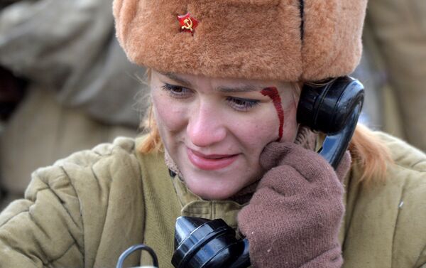Раненая девушка-телефонистка передает по телефону приказы во время инсценировки. - Sputnik Беларусь
