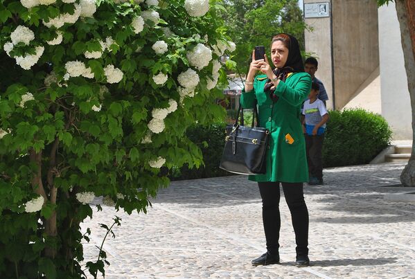 Девушка фотографирует цветы у мавзолея Абулькасима Фирдоуси - Sputnik Беларусь