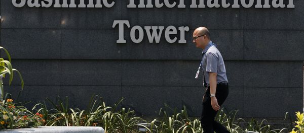 Человек проходит мимо логотипа Jasmine International Tower в Бангкоке - Sputnik Беларусь