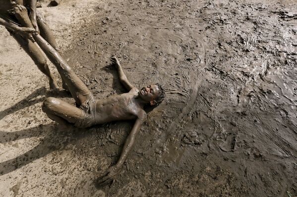 Дети играют в грязи, чтобы охладиться, в жаркий день в Нью-Дели - Sputnik Беларусь