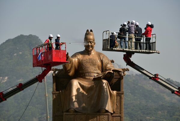 Южнокорейские рабочие водой из шланга моют бронзовую статую короля Сечжона - Sputnik Беларусь