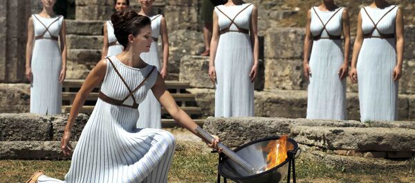 Вярхоўная жрыца запальвае Алімпіскі агонь з дапамогай парабалічнага люстэрка, якое факусуе сонечныя промні Вярхоўная жрыца запальвае Алімпіскі агонь з дапамогай парабалічнага люстэрка, якое факусуе сонечныя промні - Sputnik Беларусь