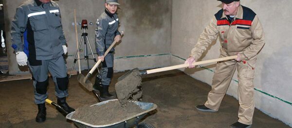 Александр Лукашенко на республиканском субботнике в столичном микрорайоне Каменная Горка на строительстве детской поликлиники вместе с сыном Николаем, 18 апреля 2015 года - Sputnik Беларусь