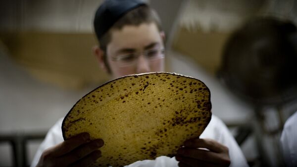 Иудей рассматривает мацу, сделанную традиционным ручным способом пресный хлеб на Песах - Sputnik Беларусь