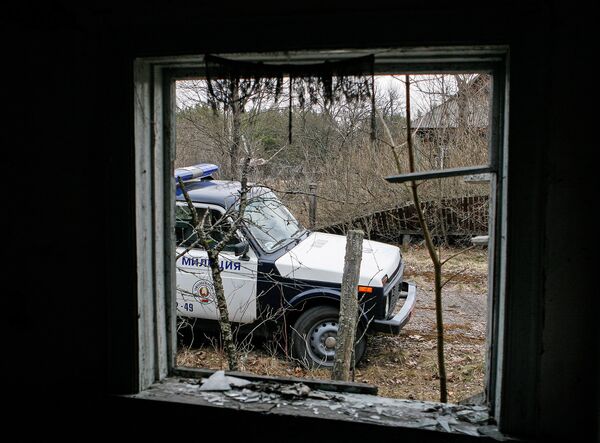 Вид на патрульную машину из брошенного дома в зоне отчуждения ЧАЭС. Сотрудники милиции обычно осматривают пустующие дома, нет ли там посторонних лиц. - Sputnik Беларусь