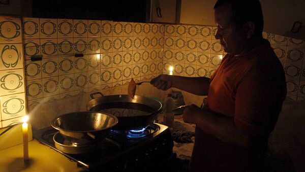 Житель Венесуэлы готовит еду при свечах, экономя электричество - Sputnik Беларусь