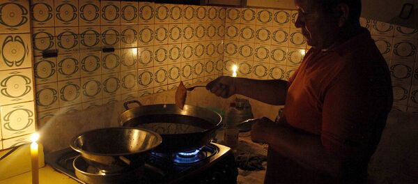 Житель Венесуэлы готовит еду при свечах, экономя электричество - Sputnik Беларусь