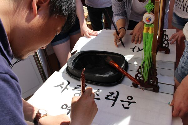 Корейские мастера пишут тушью пожелания гостям подворья на шелковичной бумаге - Sputnik Беларусь