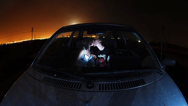 Парень и девушка целуются в автомобиле. Архивное фото - Sputnik Беларусь