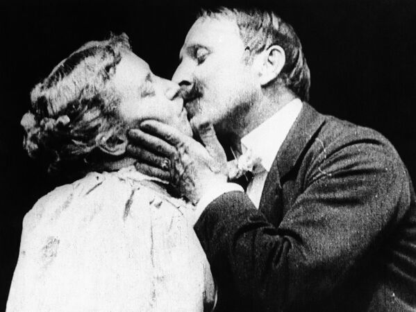А это первый поцелуй, показанный в кино. Это сцена из фильма Томаса Эдисона Поцелуй с Маей Ирвин и Джоном С. Райсом. Она шокировала аудиторию в 1896-м. Затем поцелуи в Голливуде становились все длиннее и жарче, и наконец в 1930-м их практически запретили кодексом Хейса. - Sputnik Беларусь