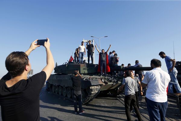 Мужчина фотграфирует людей на танке возле моста через пролив Босфор в Стамбуле - Sputnik Беларусь