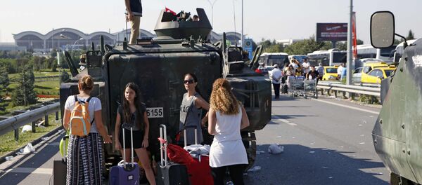 Женщины стоят возле военного автомобиля перед аэропорта Сабиха в Стамбуле - Sputnik Беларусь