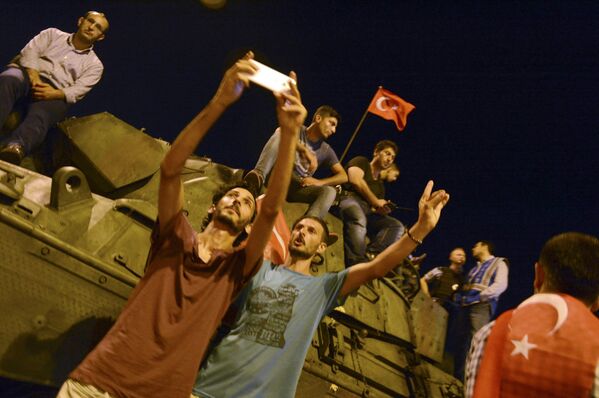 Сторонники президента Турции Тайипа Эрдогана делают селфи возле бронетранспортера в аэропорту Ататюрк - Sputnik Беларусь