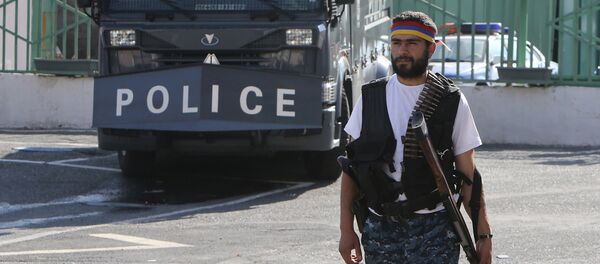 Вооруженный человек возле здания ППС, захваченного членами группировки Сасна црер - Sputnik Беларусь