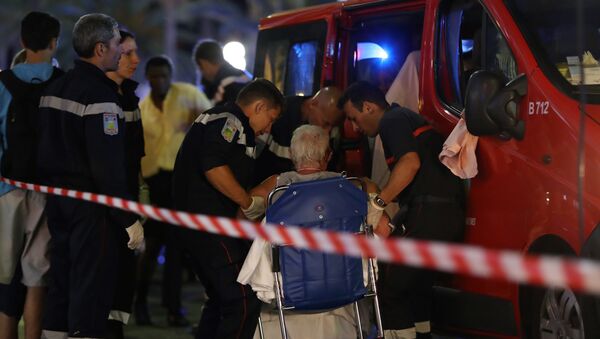 Rescue workers help an injured woman to get in a ambulance on July 15, 2016, after a truck drove into a crowd watching a fireworks display in the French Riviera town of Nice. - Sputnik Беларусь