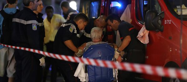 Rescue workers help an injured woman to get in a ambulance on July 15, 2016, after a truck drove into a crowd watching a fireworks display in the French Riviera town of Nice. Rescue workers help an injured woman to get in a ambulance on July 15, 2016, after a truck drove into a crowd watching a fireworks display in the French Riviera town of Nice. - Sputnik Беларусь
