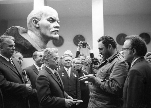 Бывшие белорусские партизаны вручают Фиделю Кастро памятный подарок - пистолет ТТ - во время официального визита премьер-министра Республики Куба в Белорусскую ССР. - Sputnik Беларусь
