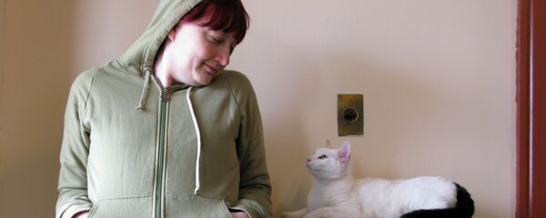 Женщина с кошкой у батареи - Sputnik Беларусь