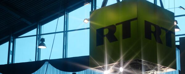 Куб с логотипом телеканала Russia Today в павильоне - Sputnik Беларусь