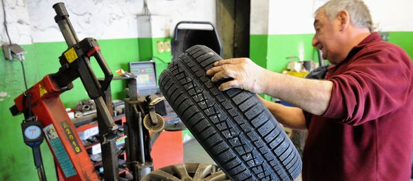 Работник шиномантажа, архивное фото Работник шиномантажа, архивное фото - Sputnik Беларусь