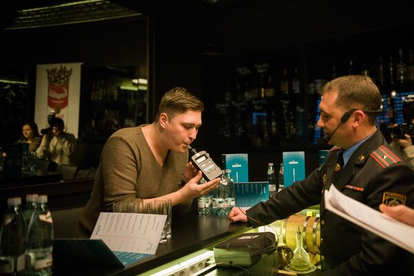 Начальника отдела агитации и пропаганды УГАИ ГУВД Мингорисполкома Сергей Зараник проводит тест у посетителя бара Начальника отдела агитации и пропаганды УГАИ ГУВД Мингорисполкома Сергей Зараник проводит тест у посетителя бара - Sputnik Беларусь