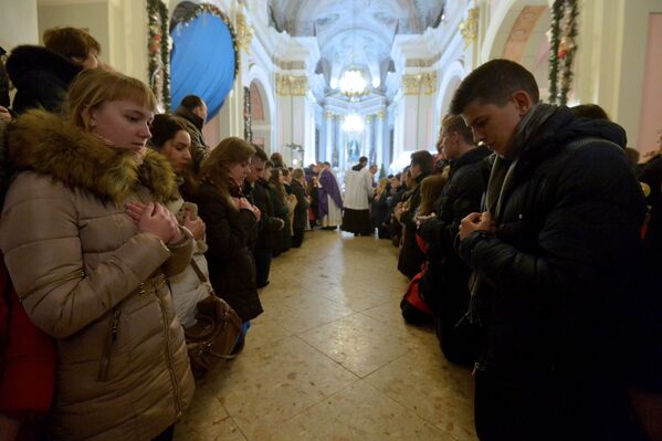 Молодые католики ожидают своей очереди на причастие во время торжественной мессы в Архикафедральном соборе Пресвятой Девы Марии в честь прибытия в Беларусь Вифлеемского огня - Sputnik Беларусь