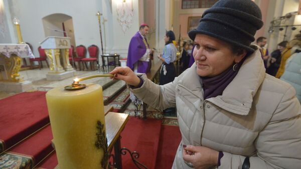 Прихожане забирают домой частичку Вифлеемского огня, зажигая свечи от лампады с Вифлеемским огнем в Архикафедральном соборе Пресвятой Девы Марии - Sputnik Беларусь