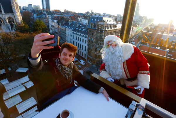 Санта-Клаус подрабатывает в знаменитом бельгийском ресторане в Брюсселе, который поднимается краном над городом - Sputnik Беларусь