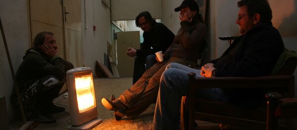 Люди греются о электрообогревателя, архивное фото - Sputnik Беларусь