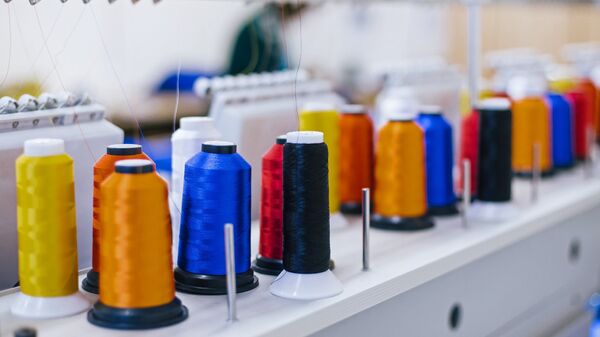 Катушки с нитками на вышивальном оборудовании в швейном цехе, архивное фото - Sputnik Беларусь
