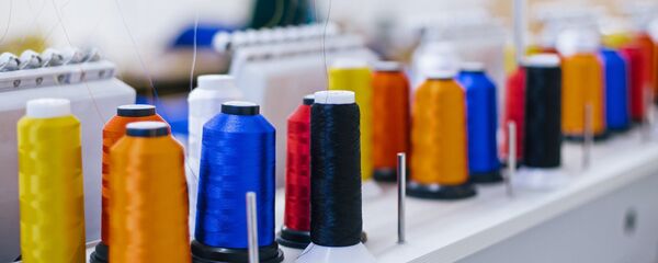 Катушки с нитками на вышивальном оборудовании в швейном цехе, архивное фото - Sputnik Беларусь