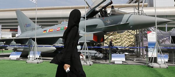 Женщина проходит мимо истребителя Eurofighter на выставке IDEX в Абу-Даби - Sputnik Беларусь
