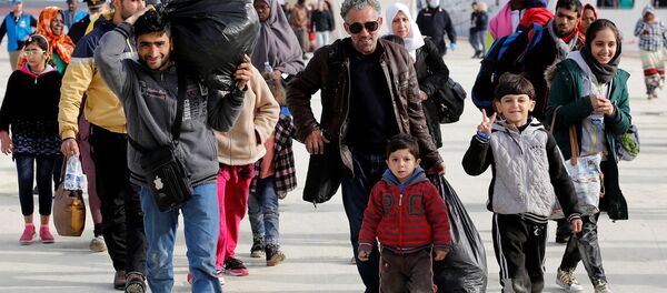 Семья мигрантов сходит на берег в сицилийском порту - Sputnik Беларусь